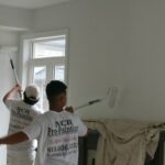 Interior House Painters rolling a family white walls
